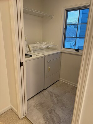 A laundry area with a washing machine, dryer, and drying rack.