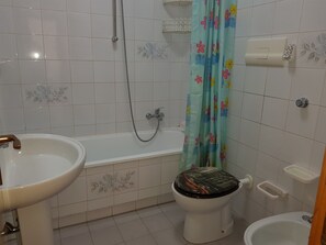 Ein Badezimmer mit Badewanne, Toilette und Waschbecken.