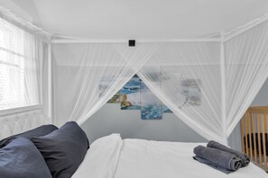 A bedroom with a canopy bed, a crib, and artwork on the wall. - Perfect 4-bedroom house with EV Charger in pleasant Buffalo neighborhood (Buffalo)
