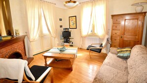 Ein Wohnzimmer mit Kamin, Holzmöbeln, einem Fernseher und einer Lampe.