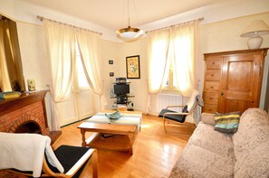 Ein Wohnzimmer mit Kamin, Holzmöbeln, einem Fernseher und einer Lampe.