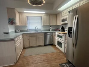 A modern kitchen with light wood cabinets, stainless steel appliances, a built-in oven, and a refrigerator. - 5 minute walk to the beach. The Mermaid House 2-bedroom in Cape Canaveral! (Cape Canaveral)