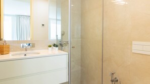 A modern bathroom with a glass shower enclosure, a white vanity with a sink, and a mirror. - Central & Trendy w/ Balcony by LovelyStay (Porto)