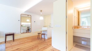 Moderni keittiö, jossa on suuri peili, puulattia ja ruokailutila, jossa on baarituoleja.