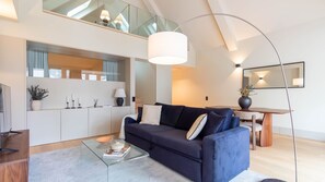 Ein modernes Wohnzimmer mit einer Couch, einem Couchtisch und einem Essbereich mit Tisch und Stühlen.