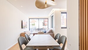 Un interno moderno con un tavolo da pranzo, sedie, un divano e un'ampia finestra.