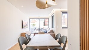 Et moderne interiør med et spisebord, stole, en sofa og et stort vindue.