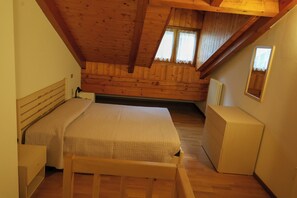 A bedroom with a wooden ceiling, two beds, a dresser, and a window. - Vrbo Property (Mastellina)