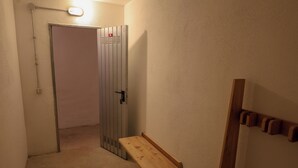 A hallway with a door, a bench, and a wall-mounted hook. - Apartment 6 Maso Anna (Mastellina)