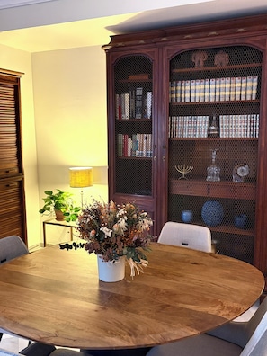 A dining table with chairs, a potted plant, a bookshelf, and a lamp. - Casa Sefarad - Spacious and bright apartment in Seville historic Jewish Quarter (Seville)