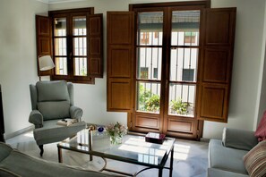 Ein Wohnzimmer mit einer Couch, einem Sessel und einem Glastisch.