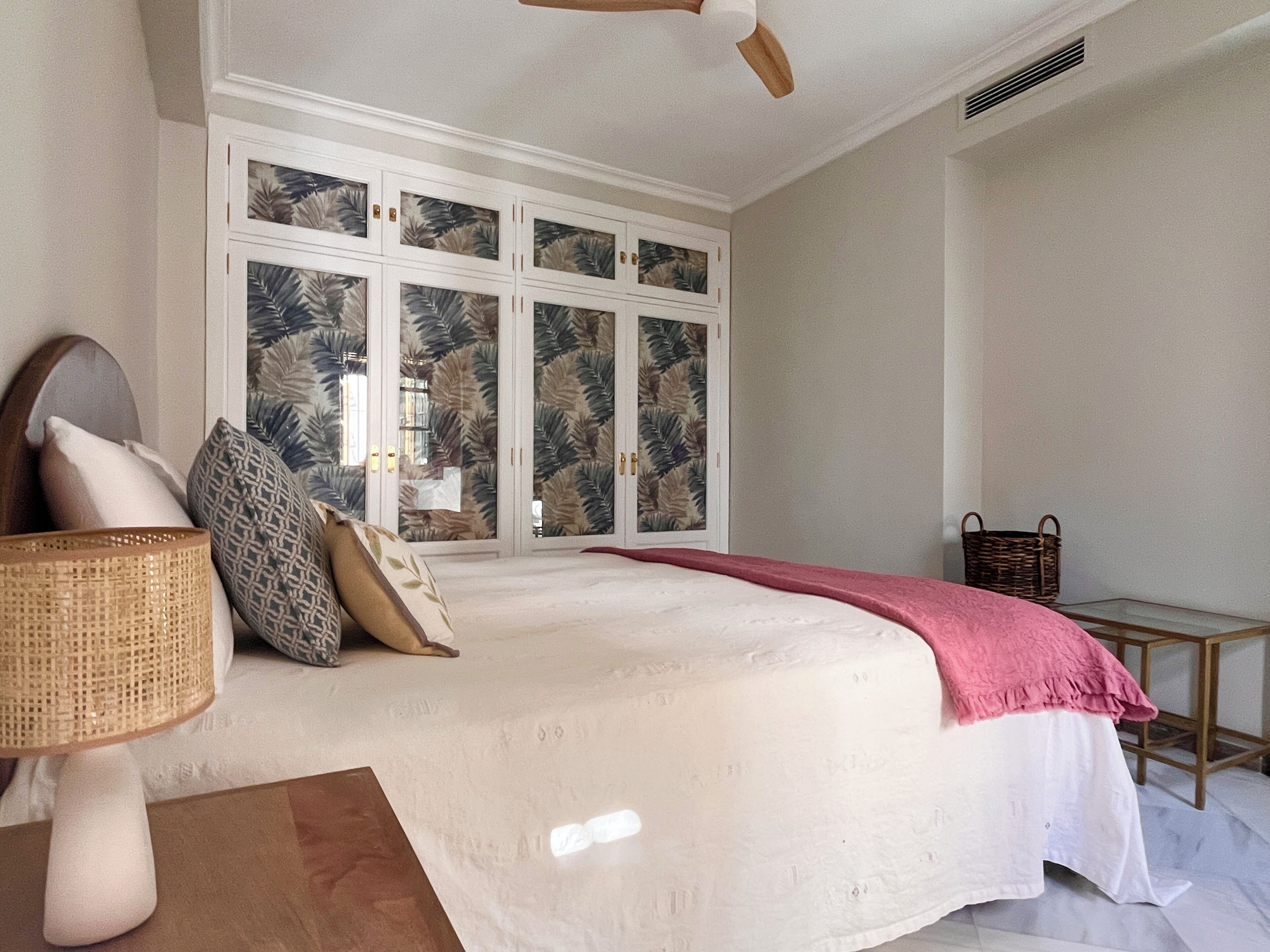 Ein Schlafzimmer mit Bett, Fenster mit Aussicht, Deckenventilator und Nachttisch.
