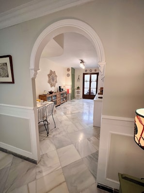 A spacious kitchen with a dining area, featuring a marble floor, an archway, and a decorative wall piece. - Casa Sefarad - Spacious and bright apartment in Seville historic Jewish Quarter (Seville)