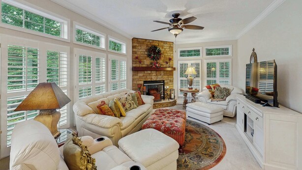 A spacious living room with a fireplace, white furniture, and large windows. - Ward Retreat (Sylva)