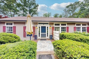 A two-story house with a front porch, a welcome mat, and a yellow umbrella. - Cozy house w/ mountain views, deck, outdoor dining, dog-friendly, jacuzzi, w/d (Sylva)