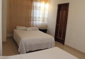 Ein Schlafzimmer mit einem Bett, einem Nachttisch und einer Tür.