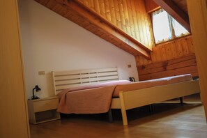 A bedroom with a wooden ceiling, a single bed, a nightstand, and a window. - Vrbo Property (Mastellina)