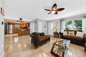 A spacious living area with a modern kitchen, a dining table, and a comfortable sofa set. - Tropical Largo Pool House Near Beaches | Private Pool Retreat (Largo)