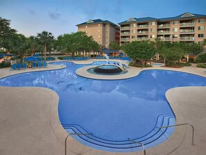 A swimming pool with lounge chairs, a hot tub, and a building with balconies in the background. - Resort with 2 bedrooms and AC in beautiful Marriott Grande Ocean (Hilton Head Island)