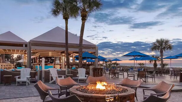 A beachside outdoor seating area with a fire pit, lounge chairs, and umbrellas. - Resort with 2 bedrooms and AC in beautiful Marriott Grande Ocean (Hilton Head Island)
