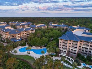 A hotel complex with multiple buildings, a central swimming pool, and surrounding greenery. - Resort with 2 bedrooms and AC in beautiful Marriott Grande Ocean (Hilton Head Island)