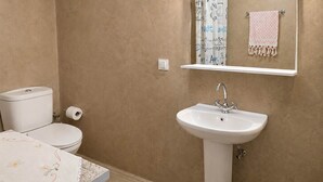 A bathroom with a toilet, sink, and mirror. - Elegant Studio in Chios Near the Beach and Port (Chios)