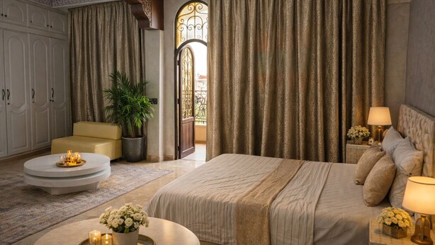 Ein Schlafzimmer mit einem großen Bett, einem Sofa, einem runden Couchtisch und einem Blumentopf.