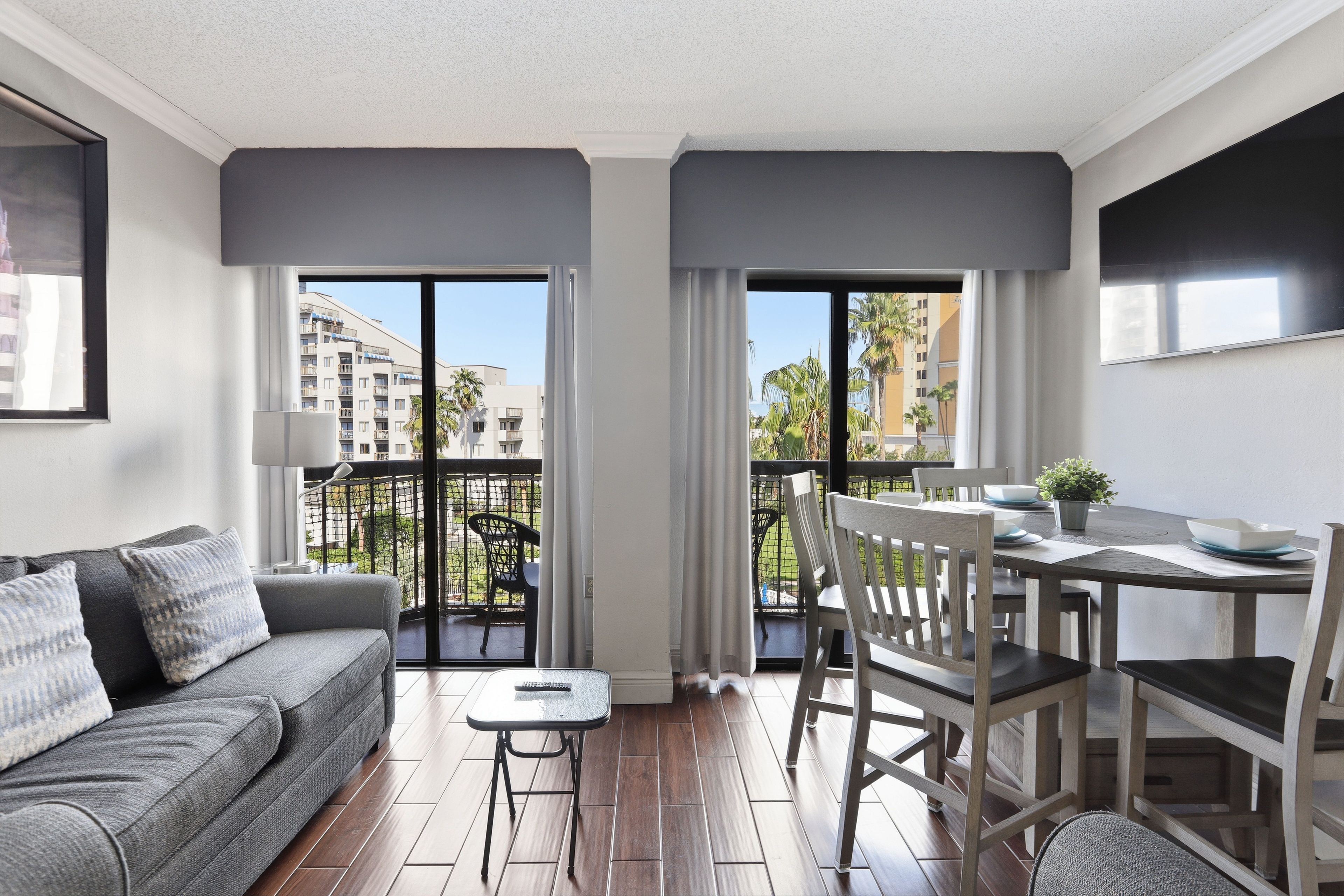A modern apartment with a balcony, a dining area, and a sofa.