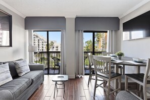 A modern apartment with a balcony, a dining area, and a sofa. - Orlando Family Resort - 2 Miles to Universal! (Orlando)