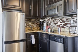 A modern kitchen with stainless steel appliances, a granite countertop, and a patterned backsplash. - Orlando Family Resort - 2 Miles to Universal! (Orlando)