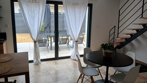 Ein Essbereich mit einem runden Tisch, Stühlen und einer Treppe.