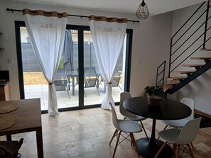 Ein Essbereich mit einem runden Tisch, Stühlen und einer Treppe.