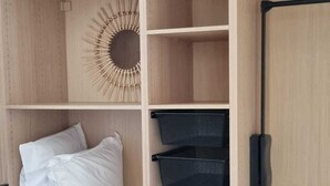 Ein Holzschrank mit drei schwarzen Netzeinlagen, einer runden Wanddekoration und einem schwarzen Griff an der rechten Tür.