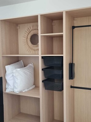 Ein Holzschrank mit drei schwarzen Netzeinlagen, einer runden Wanddekoration und einem schwarzen Griff an der rechten Tür.
