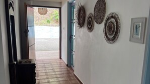 A hallway with a tiled floor, a door, and wall-mounted decorations.