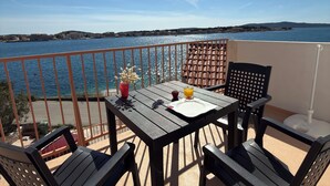 A balcony with a table, chairs, and a view of the sea. - Apartment right by the sea - 2 balconies, sea view of Krapanj (Brodarica)