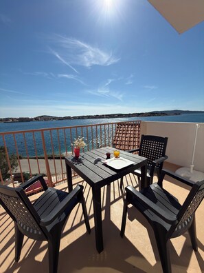A balcony with a table, chairs, and a view of the sea. - Apartment right by the sea - 2 balconies, sea view of Krapanj (Brodarica)