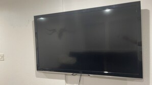 Seinälle asennettu litteänäyttöinen televisio, ja seinä on maalattu valkoiseksi.