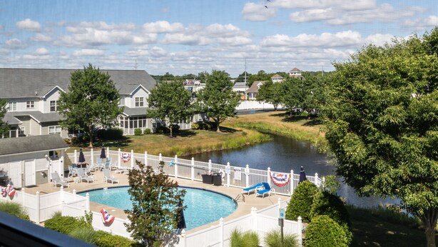 Un quartier résidentiel avec une piscine, des clôtures blanches et des maisons.