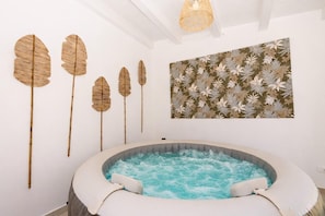 A spa room with a hot tub, wall-mounted wooden leaf decorations, and a floral-patterned wall art piece. - Villa Harem - Santa Maria Del Fo... (Santa maria del focallo)