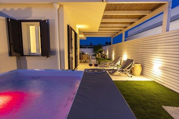 Un patio al aire libre con mesa de billar, sillas de descanso y una pequeña mesa con bebidas.