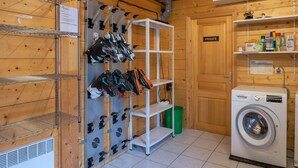 Ett tvättrum med en tvättmaskin från Bosch, hyllor med skor och en skylt med texten ”PRIVAT”.