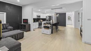 Een moderne woonruimte met een keuken, eethoek en zithoek.