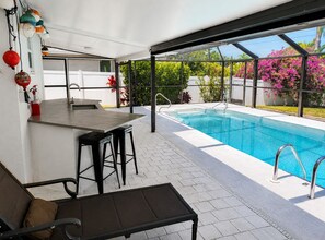 A poolside area with a bar, seating, and a view of the pool. - Coastal Naples Escape Private Pool, Sleeps 12, Vanderbilt Beach 5 mins away (Naples)