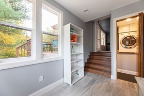 Ein modernes Interieur mit Treppe, Holztür und Blick ins Freie.