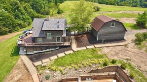A two-story house with a deck and a separate barn.