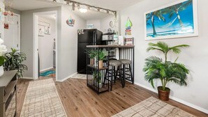 A kitchen with a black refrigerator, a bar stool, and a potted plant. - Luxury Renovated | Pool | Hot Tub | Sleeps 20 (New Plymouth)