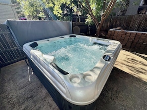 A hot tub with a cover, surrounded by a brick wall and a wooden fence. - 1 Bell Rock Villas 2BR Condo w/ Red Rock Views (Sedona)