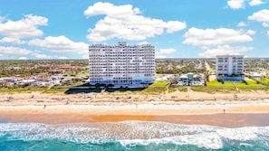 A beachfront hotel with multiple floors, a pool, and a beach area. - Oceanfront Condo, Patio, Pool & Beach Access (Ormond Beach)