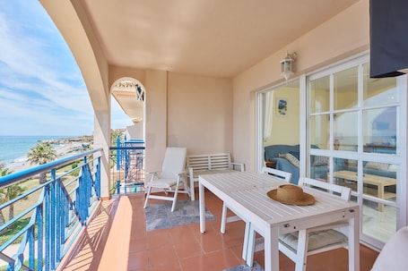 A balcony with a table, chairs, and a hat.. Apartment 'Blue View' with Sea View, Wi-Fi and Air Conditioning